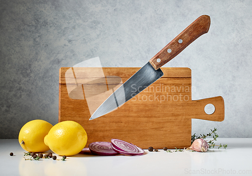 Image of wooden cutting board and levitating knife