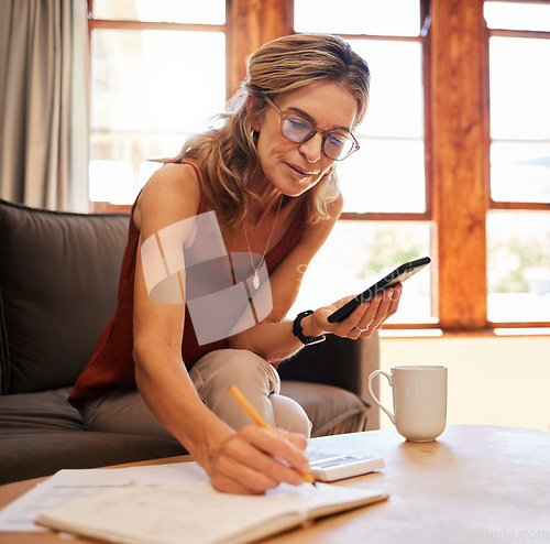 Image of Senior woman, phone and writing calculation in book on sofa, web search or investment planning. Retirement, elderly female and 5g mobile, internet banking or budget and savings with coffee in house.