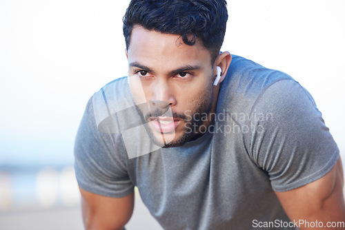 Image of Man tired during fitness workout, breathing and running exercise routine for health and wellness. Earphone, endurance, and cardio training, young person working out and take a break.