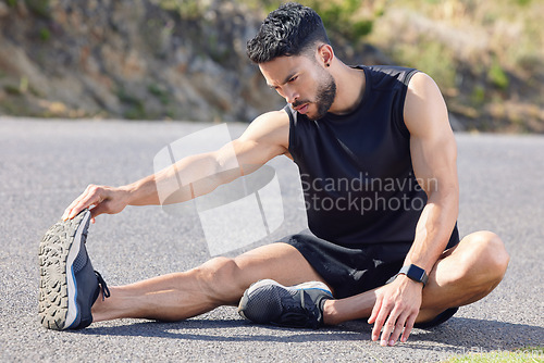 Image of Fitness, exercise and stretching with a sports man preparing for a workout or cardio training on a road in nature. Health, wellness and performance with a male athlete at the start of a routine