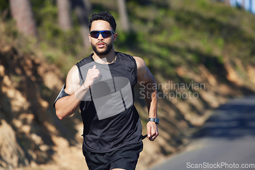 Image of Running, man and outdoor cardio fitness in nature for wellness, marathon training and healthy lifestyle in Dubai, UAE. Sports athlete, speed runner and morning exercise with sunglasses on summer road