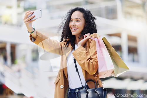 Image of Fashion, shopping and woman taking a selfie in the city standing in the street. Black woman with shopping bags, phone in hand and taking a picture in retail shopping mall, happy from sale or discount