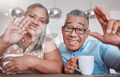 Image of Senior couple, coffee and wave for video call smiling, talking or speaking at home. Elderly man and woman greeting on social media or face time while enjoying a warm beverage indoors