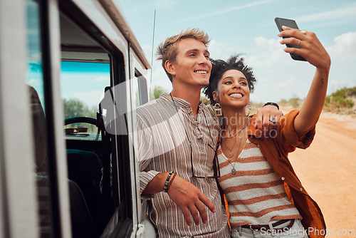 Image of Couple, phone selfie and safari travel on game drive in nature environment, sand desert or dry Kenya landscape. Smile, happy and bonding interracial man and woman with 5g mobile technology photograph