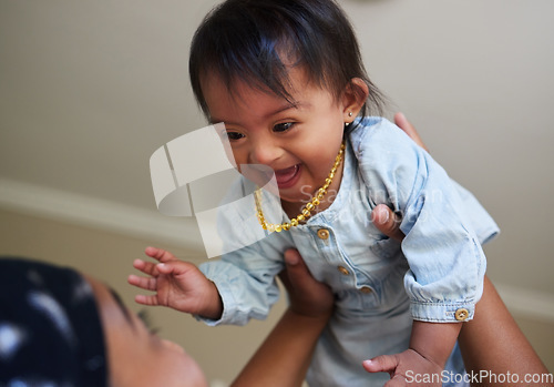 Image of Children, down syndrome and fun with a girl and mother playing together in their home. Family, kids and disability with an adorable or cute daughter laughing with her parent while being playful