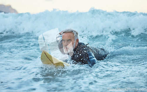 Image of Beach, surfer and old man on surfboard swimming in nature enjoying dangerous water sports and retirement. Training, fitness and senior athlete surfing on the sea waves with freedom in Los Angeles