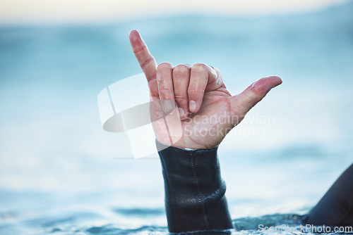 Image of Shaka, surf and man in ocean with hand sign outdoor in nature while on vacation in Australia. Surfing culture, hang loose gesture and closeup of hands of friendly surfer in water at beach on holiday.