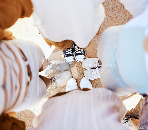 Image of Friends, group and circle with shoes together for happiness, solidarity and bonding on holiday. People, sneakers and happy together with feet on sand in fun huddle on travel, vacation or road trip