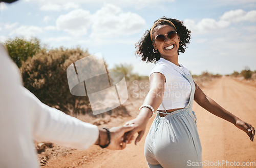 Image of Couple, walking and nature with a black woman and man outdoor holding hands on a sand road in a dessert together. Travel, love and romance with a female and male on a date during summer vacation