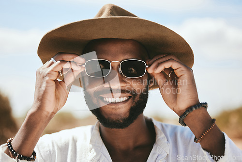 Image of Vision, style or fashion sunglasses for black man with designer, trend or cool optometry eye care. Zoom, smile or happy face of tourist, model or student on safari travel in Kenya nature environment