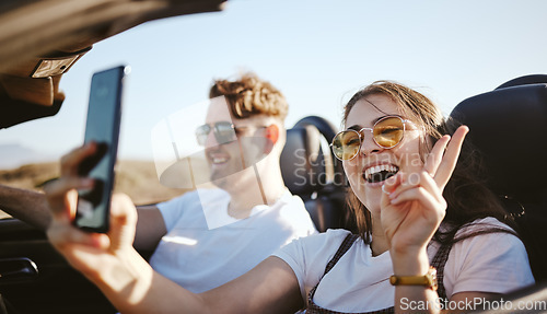 Image of Couple, phone and travel for selfie in car for social media for summer vacation and laugh together. Happy man and woman on holiday road trip on mobile smartphone with a peace sign