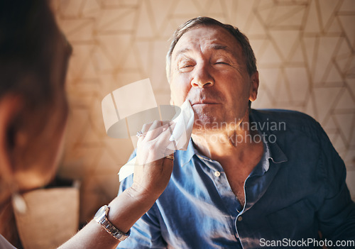 Image of Man, lunch and woman wipe mouth in retirement while together in home for breakfast, dinner or food. Elderly, couple and care with lady cleaning husband face during meal in house, cafe or restaurant