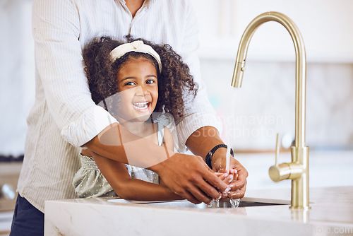 Image of Portrait of a family washing their hands for hygiene, to stop germs and health in the kitchen at home. Happy, smile and father helping his child clean her hand of bacteria, dirt and dust in a house.