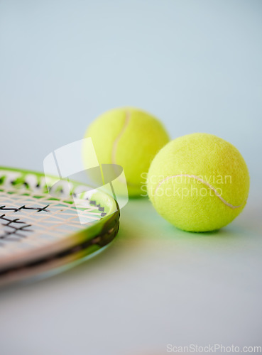 Image of Sport, tennis ball and racket in an empty studio on a gray background for sports, fitness and exercise. Training, workout and health with still life equipment on the floor ready for a game or match