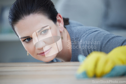 Image of Woman, focus and cleaning table in home, workplace or office for hygiene, germs or bacteria. Cleaner, precision and working on wood desk with gloves, cloth or rag in domestic service job in Warsaw