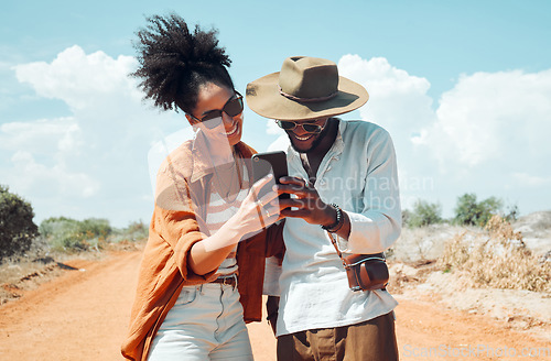 Image of Black couple with phone, travel and adventure, happy outdoors in outback Australia during summer vacation. Romantic, bonding roadtrip and smile, search for map on mobile app or internet.