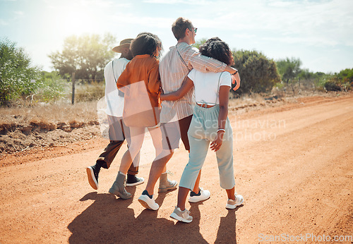 Image of Friends, hug and travel in the countryside for summer vacation walking together on a desert road in nature. People in friendship support, care and love hugging in the safari for holiday walk or trip
