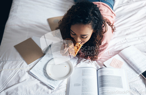 Image of Bed, girl and student studying with pizza for lunch in her bedroom reading school for tests or exams at home. Female enjoys fast food and learning from a notebook and university or college textbooks