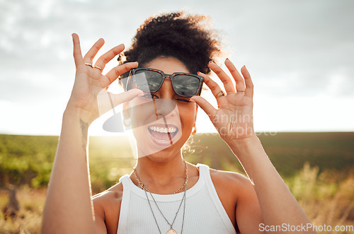 Image of Black woman smile, wink and happy on summer countryside nature holiday at sunset. Girl with fashion sunglasses, laugh with happiness and peace on relax travel vacation trip at South Africa wine farm