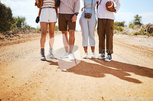 Image of Shoes, shadow and friends on a sand road in the desert for summer holiday or vacation while walking together in nature. Travel, legs and adventure with a man and woman group standing on a footpath