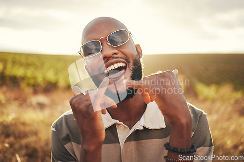 Image of Hand sign, freedom and summer with a black man enjoying nature outdoor alone during the day. Shaka, happy and carefree with a young male outside posing outside with a cheerful expression of fun