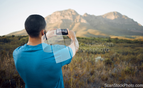 Image of Smartphone photography, mountain and hiking man in nature for outdoor adventure, social media location update or gallery memory. Young influencer taking landscape picture with cellphone for trekking