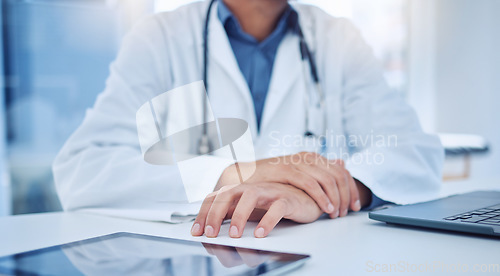 Image of Hands, tablet and healthcare with a doctor at a desk in the hospital for medicine, insurance or consulting. Trust, medical and internet with a male surgeon sitting in a clinic for health or wellness