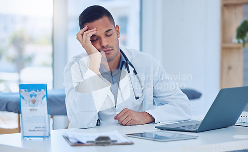 Image of Tired man in medical hospital, doctor napping at office desk and healthcare burnout in India. Exhausted stress nap from insomnia, sleeping male by laptop desk and mental health in doctors clinic