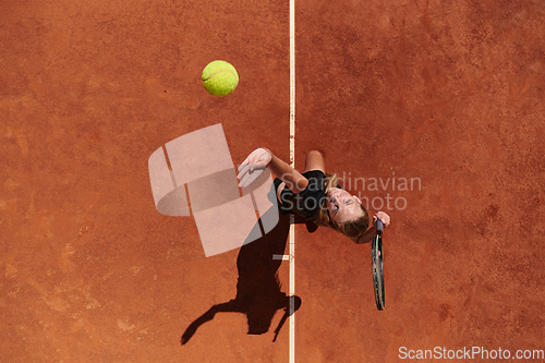 Image of Top view of a professional female tennis player serves the tennis ball on the court with precision and power