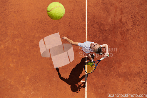 Image of Top view of a professional female tennis player serves the tennis ball on the court with precision and power