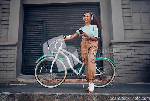 Image of Bicycle, phone and happy woman with headphones for music while on walk in the city street. Happiness, smile and girl from Puerto Rico listening to audio, podcast or radio on smartphone in urban road.