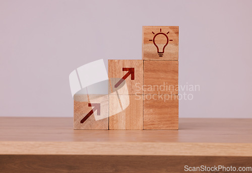 Image of Wood, blocks and idea with light bulb icon for creativity, innovation and development with wooden cubes against studio background. Brainstorming, conclusion and motivation for growth, action or goal