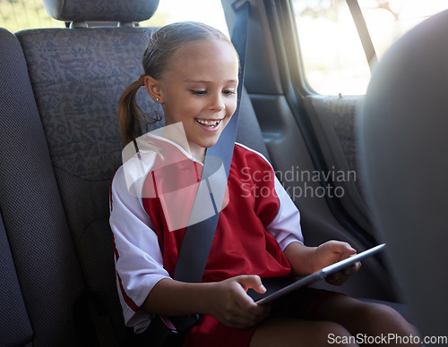 Image of Happy, girl child and with tablet in car smile, browse online and use social media apps while buckled up. Female kid, use digital device or after practice, share winning soccer match or playing game