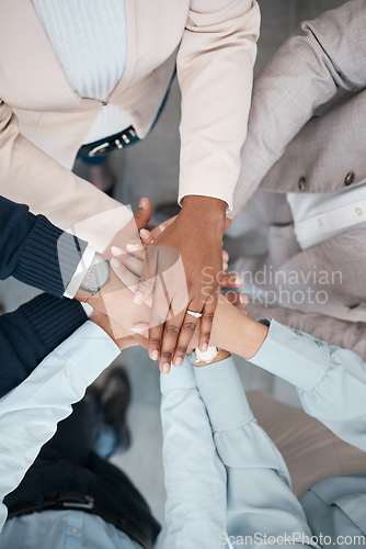 Image of Hands, collaboration and solidarity with a team of business people standing in a huddle or circle in the office from above. Teamwork, motivation and unity with a man and woman employee group at work