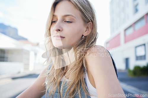 Image of Thinking girl in the street in the city, sad expression on her face. Young student sitting in road in urban town with mindful thoughts, depression and mental health. Woman alone, sadness and stress