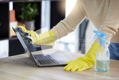 Image of Laptop, cleaning and hands with an office cleaner wiping a computer on a desk or table with sanitizer. Hygiene, disinfectant and rubber gloves with a woman dusting or washing wireless technology