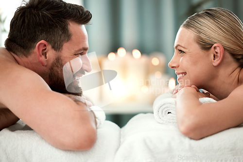 Image of Spa, smile and couple on massage bed table for luxury messaging, relax and zen on holiday in hotel resort. Wellness, happy man and woman looking into eyes in body care treatment or vacation together.