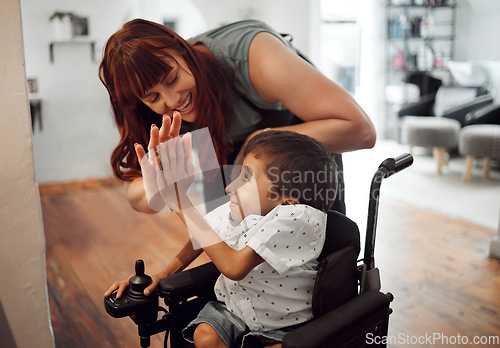 Image of Hairdresser, high five and child with disability in salon happy with haircut. Kid in wheelchair, stylist in inclusive barbershop and smile with success. Support, happiness and accessible care for boy