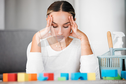 Image of Stress, headache and cleaning with an upset woman or mother in her home to clean up kids toys. Tired, exhausted and overworked with a female parent in her house, stressed or annoyed about mess