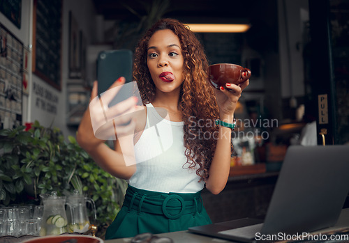 Image of Selfie, coffee shop and funny with a woman customer using a laptop and phone in her local cafe. Silly, face and mobile with a young female posting a photograph on the internet while in a restaurant