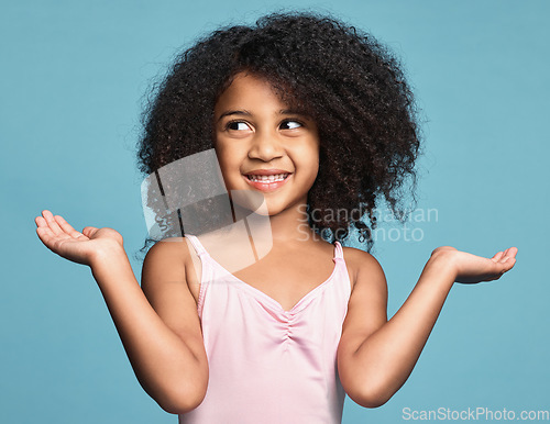 Image of Girl, hands and smile with confused, question and guess against studio background. Kid, model and confusion do sign for doubt against blue backdrop with shrug, afro and natural hair on surprise child