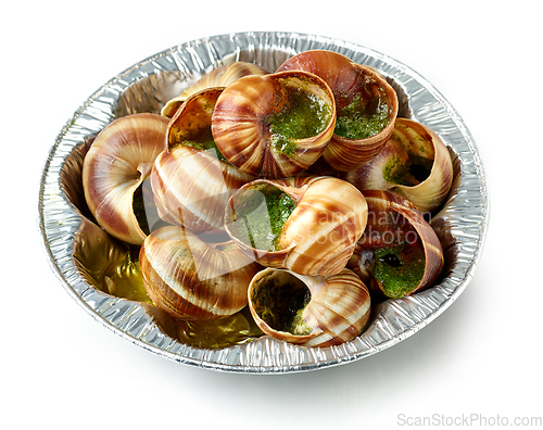 Image of plate of baked escargot snails filled with parsley and garlic bu