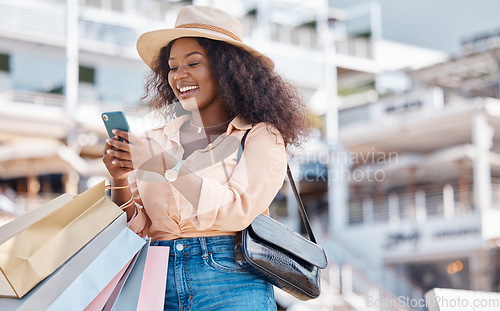 Image of Shopping bag, smartphone and black woman in city with retail sale announcement, newsletter discount code or ecommerce website. Wealth, success customer in urban outdoor using phone for online choice