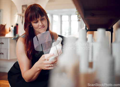 Image of Hairdresser, salon and professional stylist woman reading shampoo or keratin beauty treatment products for hair care. Happy female or owner in startup hairdressing business while checking inventory