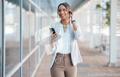 Image of Earphones, phone and business woman in city streaming audio, podcast or music. Smile, relax and female from India walking, on break or 5g mobile app listening to radio sound track on street outdoors