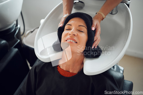 Image of Woman, hairdresser and hair care being relax, with head dry with towel after wash in basin. Salon, beauty spa and professional stylist with senior client, for hairstyle change and happy with service