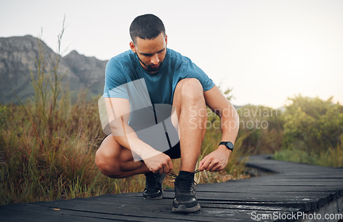 Image of Hiking shoes, nature and man on trail to hike for wellness, health and exercise in the countryside. Forest, sports and healthy guy tying trekking boots on adventure walkway or path in South Africa.