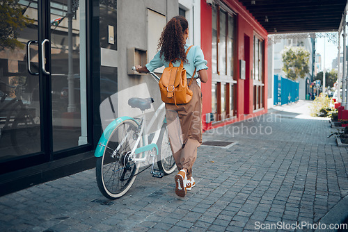 Image of Bike, city and back view of black woman, walking on street or urban road outdoors. Exercise, fitness and female student on bicycle ride, eco friendly transportation and cycling on asphalt in town.