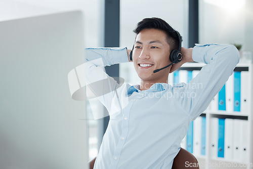 Image of Asian man in call center office stretching, relax in easy working for customer support service company in Seoul..Telemarketing agent in corporate consulting, receptionist call and employee wellness