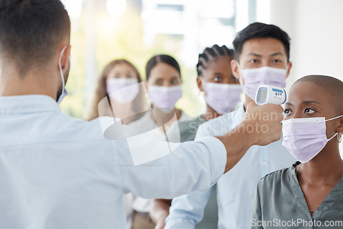 Image of Covid compliance, business and people with face mask testing with thermometer at security to check symptoms for office policy. Diversity, employees and corona virus safety for men and women at work